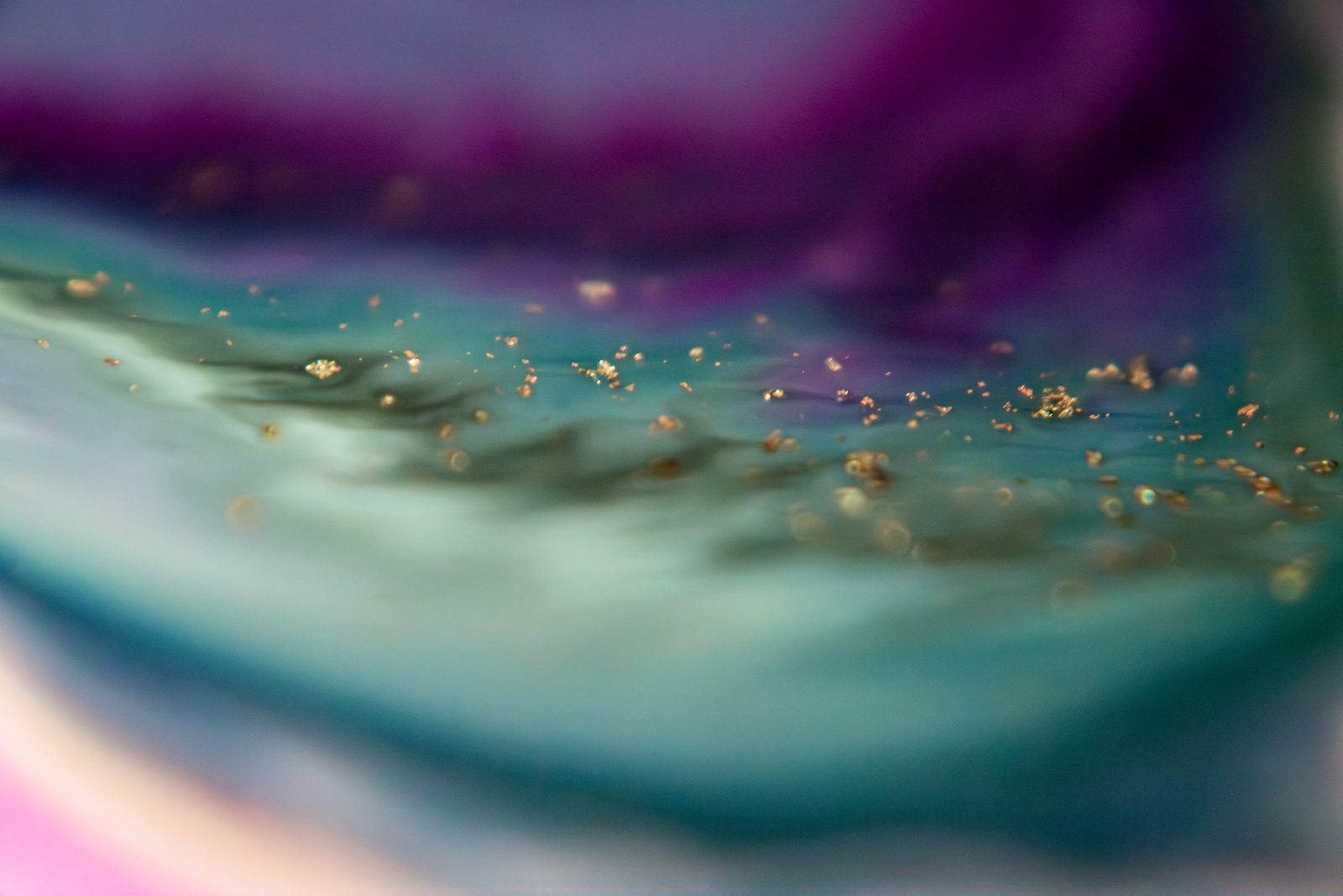 Magenta fading into teal, scattered with fine gold flecks.