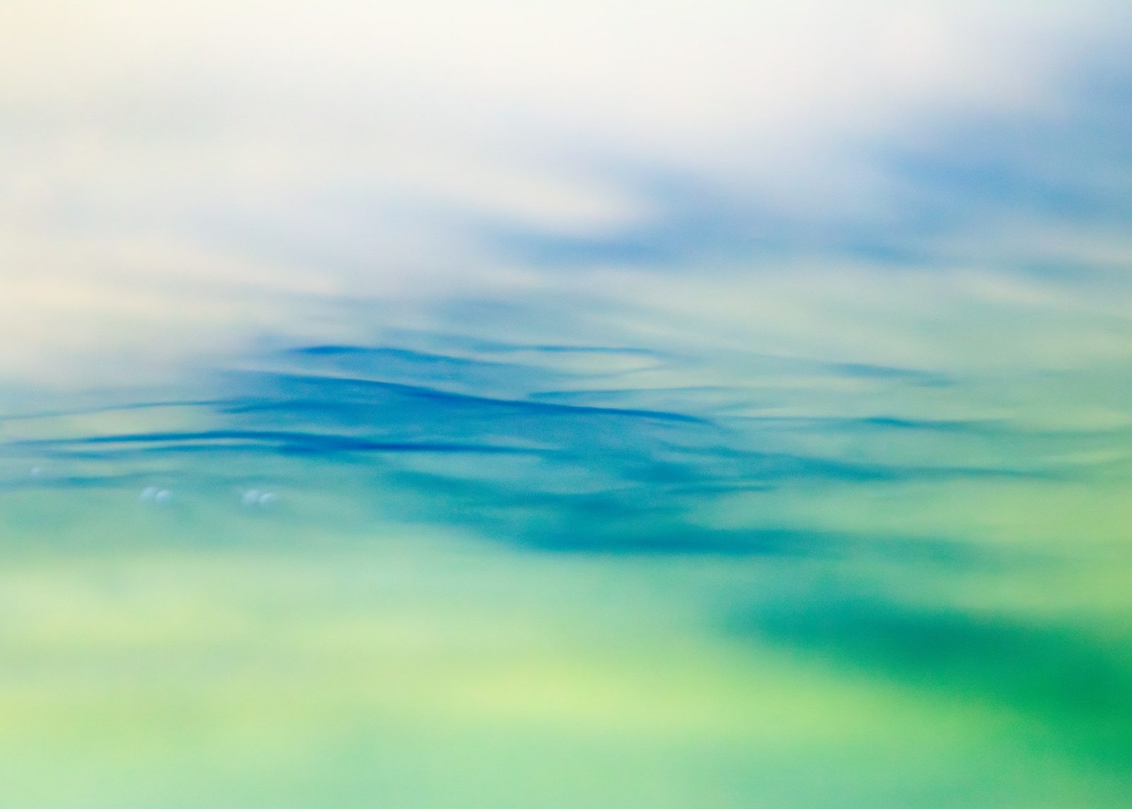 A soft blue band drifting between hazy white and pale green, like a horizon.