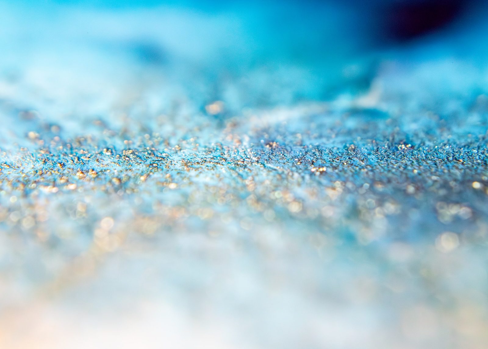 Fine pale glitter scattered across a blue-white diagonal gradient, with a dark navy corner.